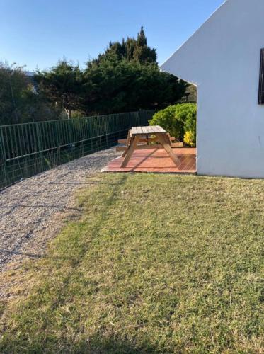 a wooden bench sitting on top of a yard at Hôtel du Pont Blanc in Saintes-Maries-de-la-Mer