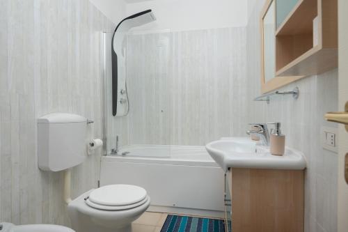 La salle de bains est pourvue de toilettes, d'un lavabo et d'une baignoire. dans l'établissement Splendida location con spiaggia privata, à Sirmione