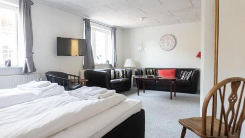 Habitación de hotel con 2 camas y sala de estar. en Hotel Smedegaarden, en Lem