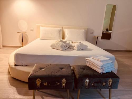 a bedroom with a large bed with towels on it at Muralta Suite & Luxury Rooms in Altamura