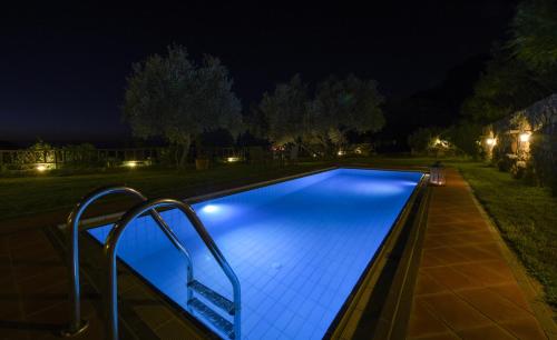 a swimming pool at night with lights on it at Malathiros Traditional Villas in Maláthiros