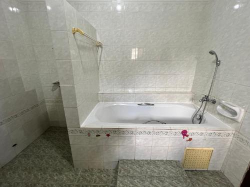 a white bath tub in a bathroom with a shower at VillaXXL & Pool, Fidjrosse, route des pêches, Cotonou in Godomè