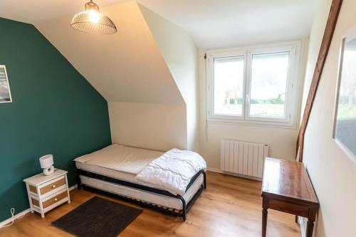 Dormitorio pequeño con cama y mesa en Le Dolmen, en Crach