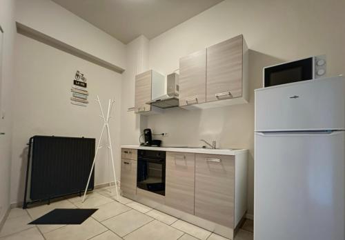 een keuken met een witte koelkast en een wastafel bij Station 173 A Bruxelles-Charleroi-airport in Charleroi