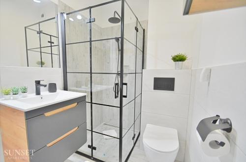 W łazience znajduje się prysznic, toaleta i umywalka. w obiekcie Sunset Apartments - Green Square + Garaż w Świnoujściu
