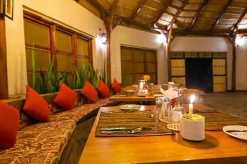 ein Esszimmer mit einem langen Tisch und roten Kissen in der Unterkunft Kazinga Wilderness Queen Elizabeth NP in Katunguru