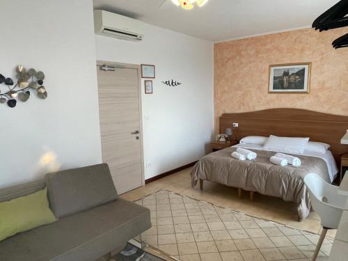 a bedroom with a bed and a couch at Hotel Panoramica in Bardolino