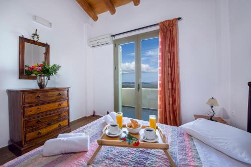 a bedroom with a bed with a tray of food on it at Malathiros Traditional Villas in Maláthiros