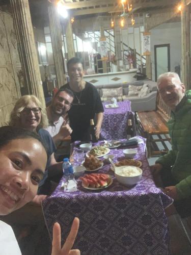 a group of people sitting around a table with food at Mai chau Horizon Homestay in Mai Chau