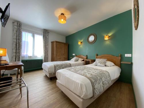 - 2 lits dans une chambre aux murs verts dans l'établissement Hôtel Restaurant Le Grillon, à Chambon-sur-Lac