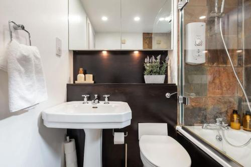 a bathroom with a sink and a toilet at Prime Covent Garden gem with Air-Con in London