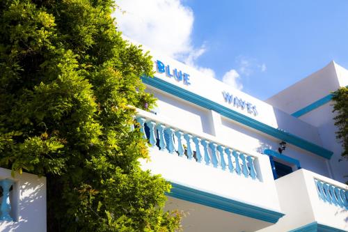 a white building with blue waves written on it at Blue Waves Studios in Kyra Panagia