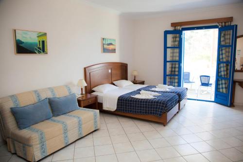 a bedroom with a bed and a couch at Blue Waves Studios in Kyra Panagia