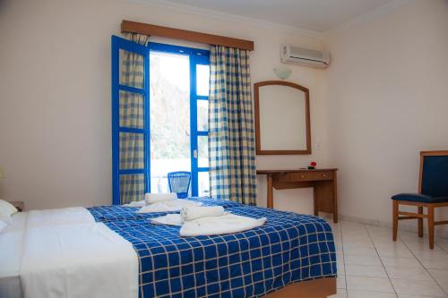 a bedroom with a blue and white bed with a mirror at Blue Waves Studios in Kyra Panagia