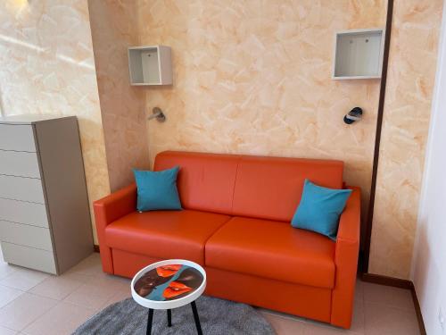 a living room with a red couch and blue pillows at Hotel Panoramica in Bardolino