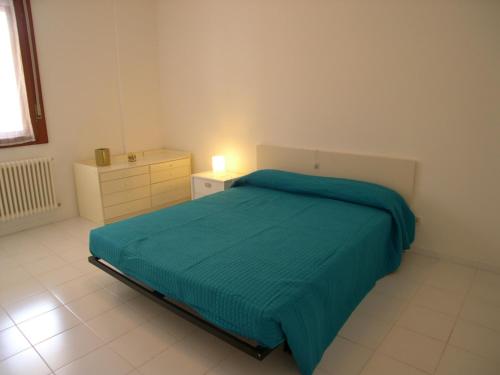 a bedroom with a bed with a green blanket at Casa Carducci in Grado
