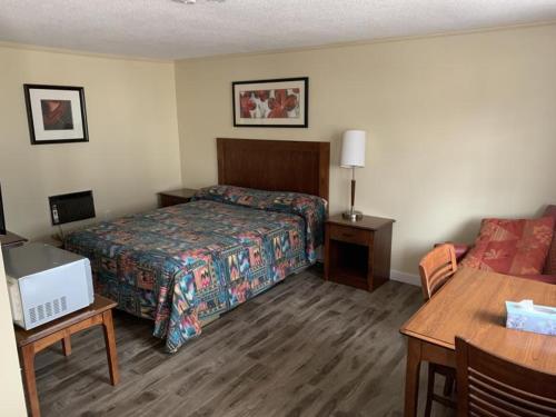 トゥルーロにあるStone-House Motel and Restaurantのベッドとテーブルが備わるホテルルームです。