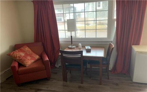 a room with a table and a chair and a window at Stone-House Motel and Restaurant in Truro