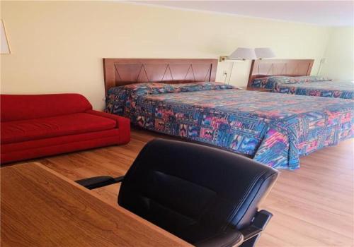 sypialnia z 2 łóżkami, krzesłem i kanapą w obiekcie Stone-House Motel and Restaurant w mieście Truro