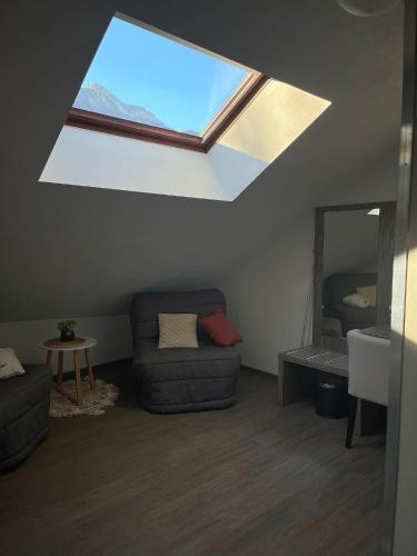 a living room with a skylight and a couch at Les Olivades in Gap
