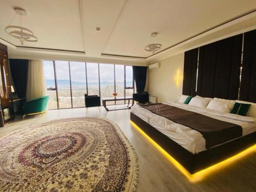 BALAND HOTEL DUSHANBE في دوسهانبي: غرفة نوم بسرير كبير وسجادة كبيرة