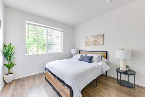 a white bedroom with a bed and a window at Spacious, Comfortable, and Central Condo in Los Angeles