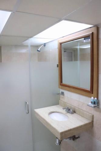 a bathroom with a sink and a shower with a mirror at Hotel Riviera in San Juan de los Lagos