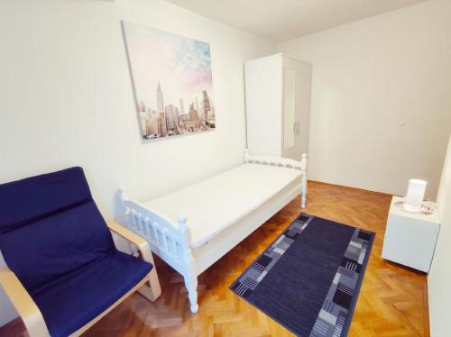 een kamer met een bed en een blauwe stoel bij Wohnung in Pula mit Terrasse, Garten und Grill in Pula