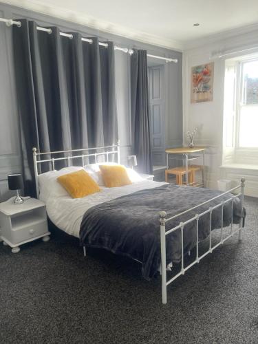 a bedroom with a large bed with yellow pillows at Lovely Getaway Apartment in Wisbech in Wisbech