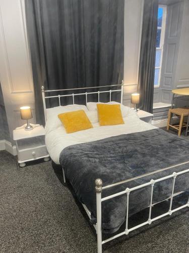 ein Schlafzimmer mit einem großen Bett mit zwei orangenen Kissen in der Unterkunft Lovely Getaway Apartment in Wisbech in Wisbech