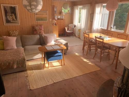 uma sala de estar com um sofá e uma mesa em Lättillgängligt och trevligt hus em Trosa