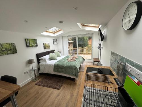 a bedroom with a bed and a clock on the wall at Little Hawthorns in New Alresford