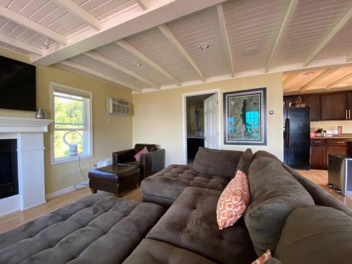 una sala de estar con un gran sofá marrón en una habitación en Beautiful Wisconsin Beach Retreat Lake Lucerne, en Crandon