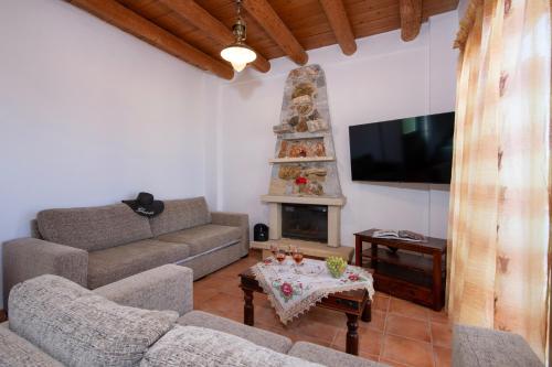 a living room with a couch and a fireplace at Malathiros Traditional Villas in Maláthiros