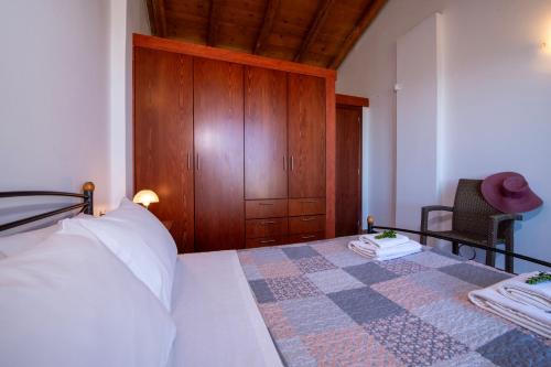 a bedroom with a bed and a wooden cabinet at Malathiros Traditional Villas in Maláthiros