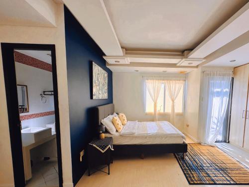 a bedroom with a bed and a sink in it at LarisZone-Luxury Courtyard Villa in Manila