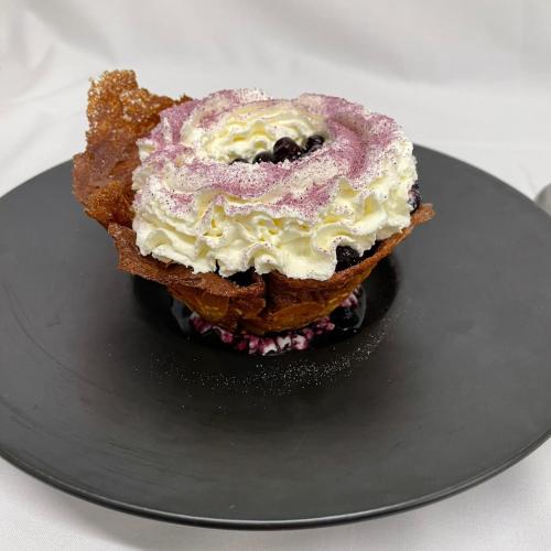 a piece of bread with a dessert on a plate at Hôtel Restaurant Le Grillon in Chambon-sur-Lac