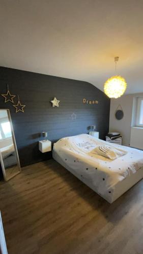 une chambre avec un lit avec des étoiles sur le mur dans l'établissement Chez Anaïs, à Dieue-sur-Meuse