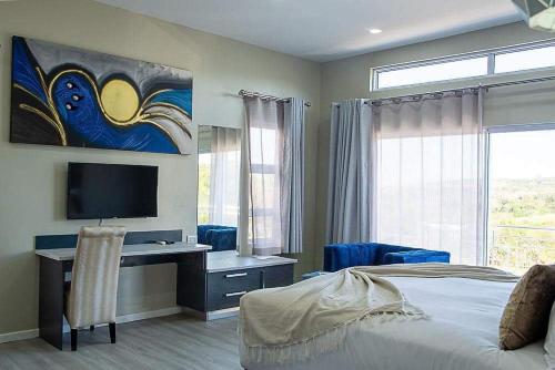 a bedroom with a bed and a desk with a television at Lilitha Boutique Hotel-East London in East London