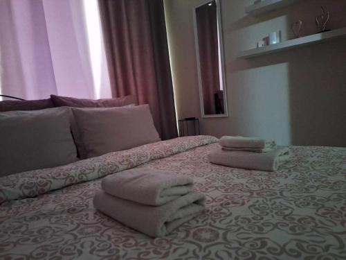 a bed with towels sitting on top of it at Apartment near the sea, Volos in Volos