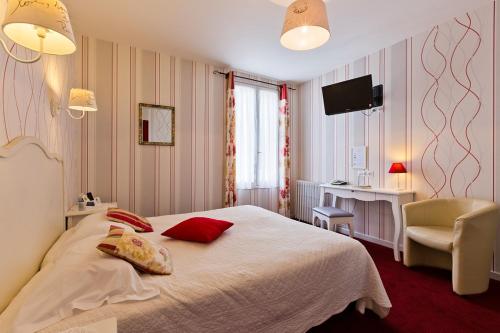a bedroom with a bed and a chair and a television at Hôtel Restaurant Le Grillon in Chambon-sur-Lac