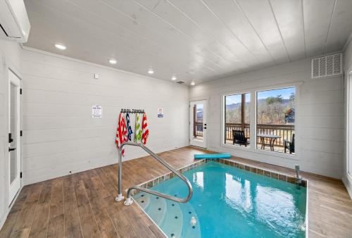 a swimming pool in a room with white walls at NEW Cabin - Heated Indoor Pool, Jacuzzi, Gameroom in Pigeon Forge