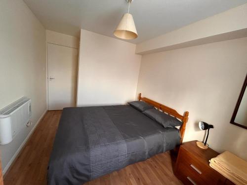 a bedroom with a bed and a table and a lamp at Specious 1 Bed Apartment free wifi and parking in Goodmayes