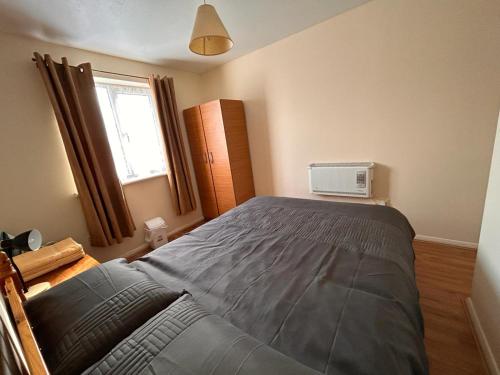 a bedroom with a large bed and a window at Specious 1 Bed Apartment free wifi and parking in Goodmayes