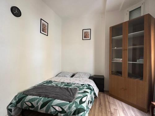 une chambre avec un lit et une armoire en bois dans l'établissement Studio Urbain Cosy-Touche Rétro, à Perpignan