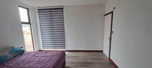 ein Schlafzimmer mit einem Bett und einem großen Fenster in der Unterkunft Casa Torres in El Cardonal