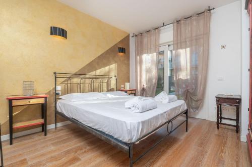 a bedroom with a large bed with white sheets at Timetofreedom Apartment Bellevue in Bardolino