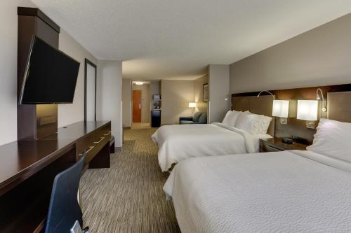 a hotel room with two beds and a flat screen tv at Holiday Inn Express Hotel & Suites Bryan-Montpelier by IHG in Holiday City