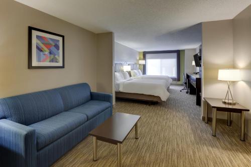 a hotel room with a couch and a bed at Holiday Inn Express Hotel & Suites Bryan-Montpelier, an IHG Hotel in Holiday City