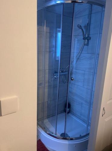 een douche met een glazen deur in de badkamer bij Telford Guest House 1 in Telford